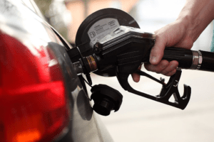 A photo of a man filling up his car with gas