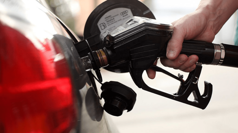 A photo of a man filling up his car with gas