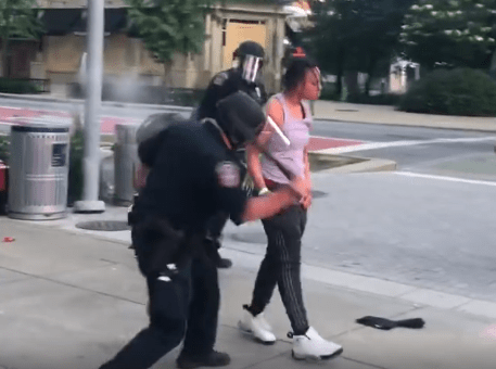 A woman is whacked with a baton as she is arrested