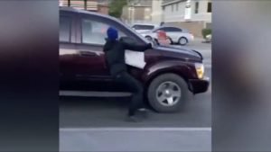 ANTIFA protestor attempts to stop vehicle with his super sticky shoes.