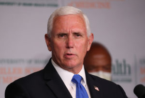 Mike Pence speaking at a press conference in a suit