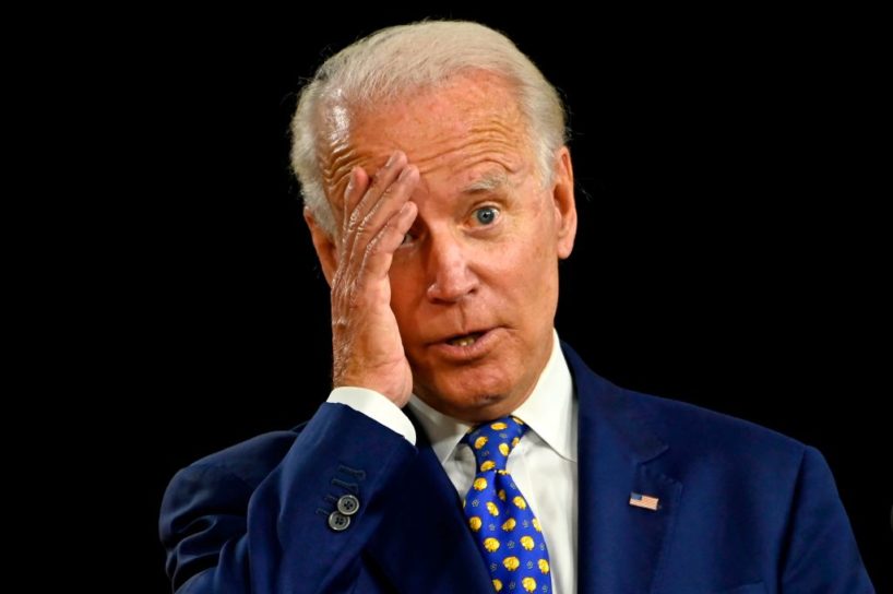 Joe Biden grabs his head, wandering off from his handlers.