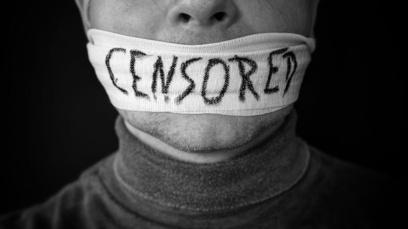 Bandaged mouth of a man with the word censored in English