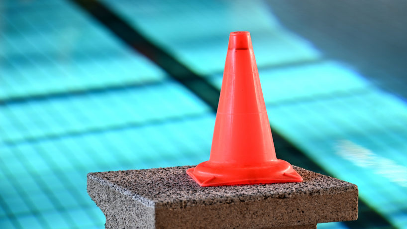 A cone on a block by a swimming pool