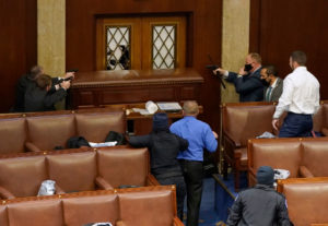 U.S. Capitol police officers point their guns at a door that was vandalized in the House Chamber during a joint session of Congress on January 06, 2021 in Washington, DC. 