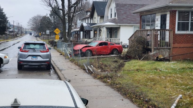 A red car crashed into a fence