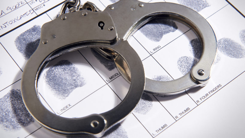 Handcuffs laying on top of fingerprint chart in file