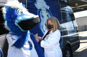 Indianapolis Colts mascot “Blue” at the Indianapolis Motor Speedway to “receive” his COVID-19 vaccination as part of the IMS mass vaccination event. Pictured with him are Dr. Elaine Cox, chief medical officer for Riley Hospital for Children at IU Health; and Mary Kay Foster (black coat), IU Health Special Pathogens program manager. Photographed at the Indianapolis Motor Speedway on 04/26/21.