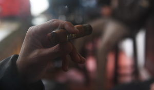 hand holding cigar lit