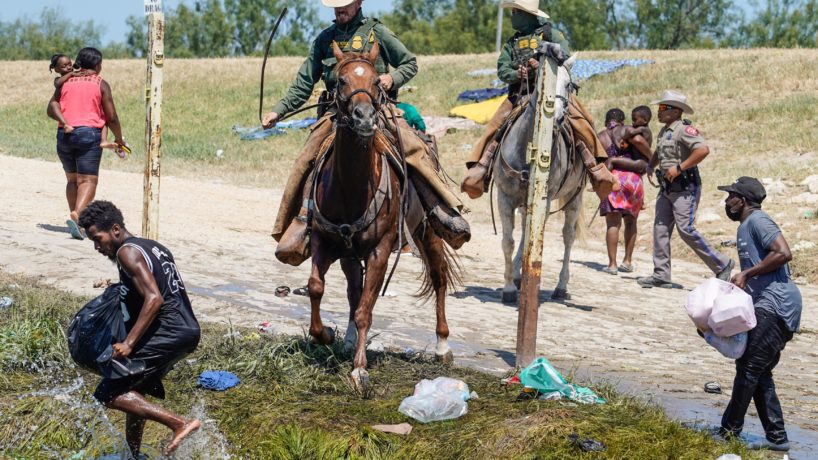 TOPSHOT - United States Border Patrol agents on horseback try to stop Haitian migrants from entering an encampment on the banks of the Rio Grande near the Acuna Del Rio