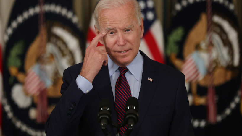 Biden at podium pointing to his head