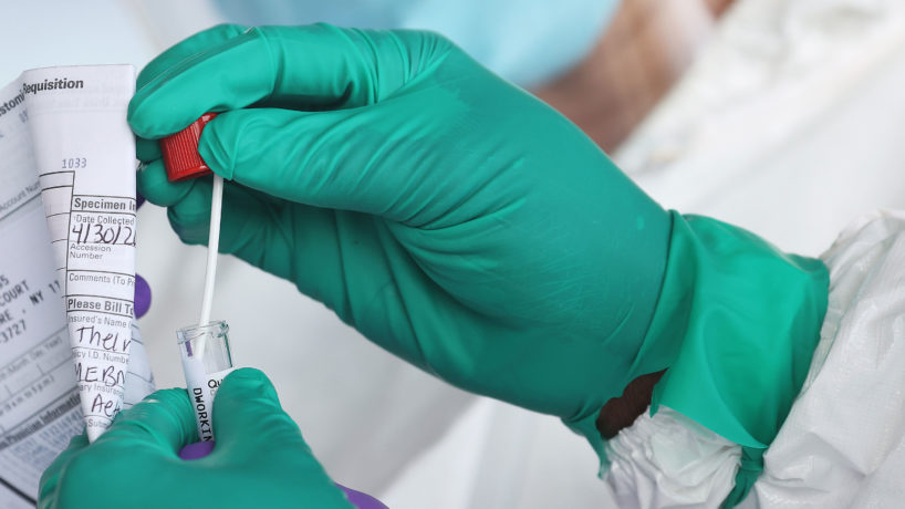 A Health Care Worker seals a coronavirus swab after testing at the Pro Health Urgent Care coronavirus testing site on April 30, 2020 in Wantagh, New York.