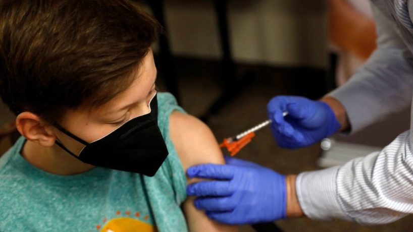 Aiden Arthurs receives the Pfizer-BioNTech Covid-19 Vaccine from Pharmacist Andrew Mac (R) at the Jewish Federation/JARC's offices in Bloomfield Hills, Michigan, on May 13, 2021.
