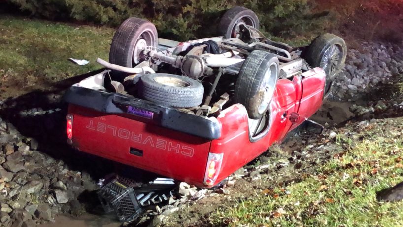 A flipped red pickup truck on its roof in Indianapolis.