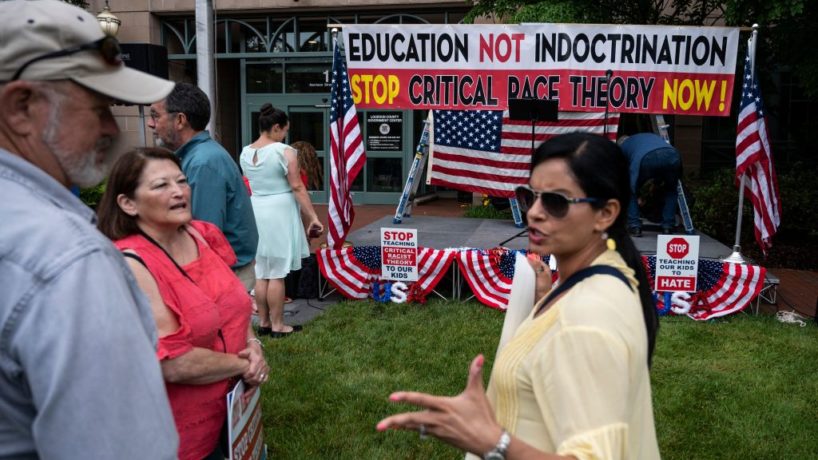 People talk before the start of a rally against "critical race theory" (CRT) being taught in schools at the Loudoun County Government center in Leesburg, Virginia on June 12, 2021.