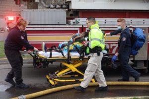 A person rolled away on a stretcher