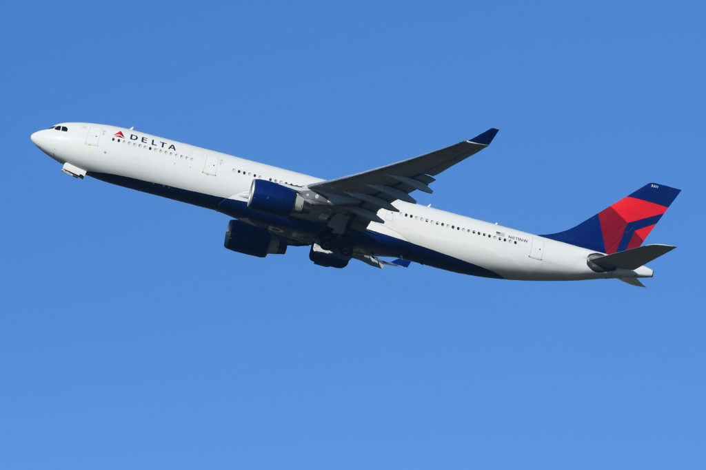 Delta Ailiner flying through a blue sky
