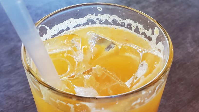 glasss of orange juice with a straw