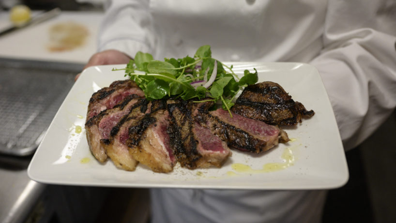 cooked and sliced steak on a plate served by chef