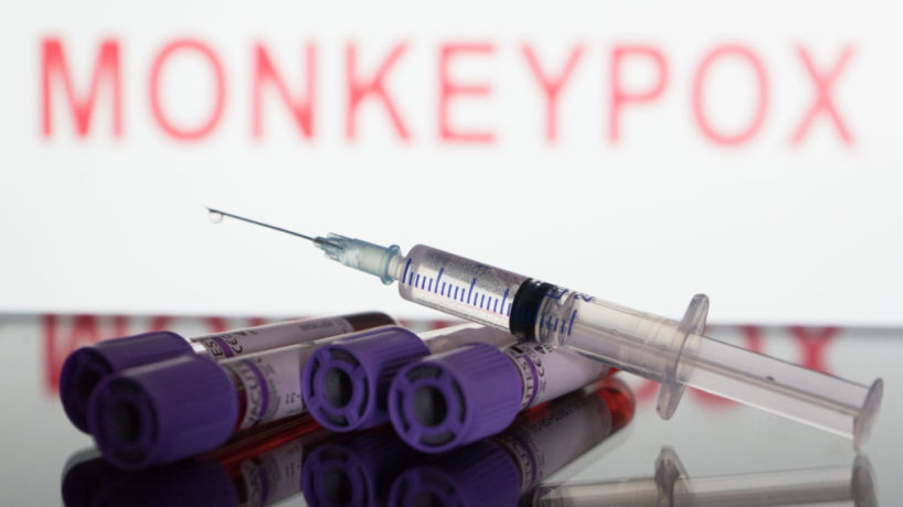 In this photo illustration, blood test vials and a syringe are seen in front of a screen that says ''Monkeypox'' (Photo illustration by Nikos Pekiaridis/NurPhoto via Getty Images)