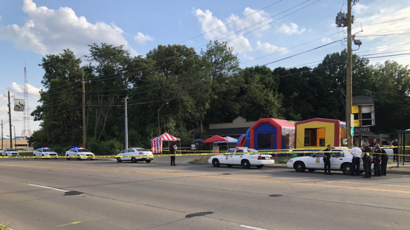 Police cars and crime scene tape in front of bouncy houses