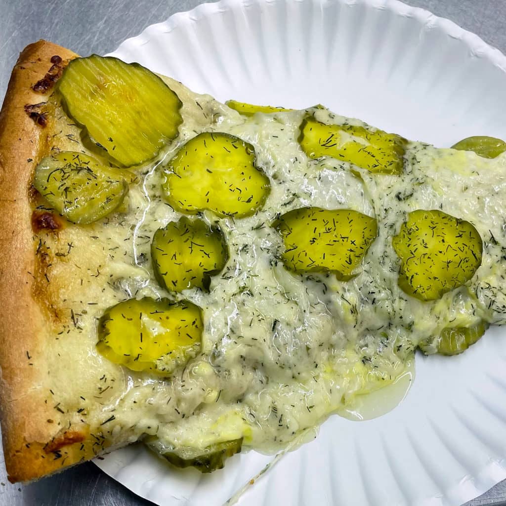 Piece of Pickle Pizza on a paper plate