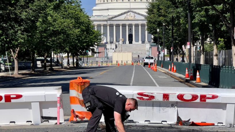 A US Capitol Police Officer works near a police barricade on Capitol Hill in Washington, DC, on August 14, 2022. - A man died early Sunday near the US Capitol building after driving his car into a barricade and firing shots into the air before turning his gun on himself, police said. (Photo by Daniel SLIM / AFP) (Photo by DANIEL SLIM/AFP via Getty Images)