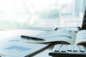 pen keyboard and financial documents laying on desk