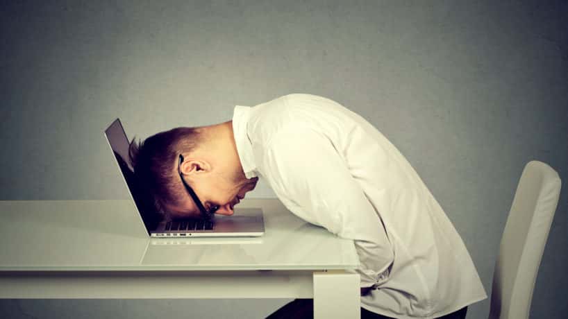 Desperate employee, stressed young man resting head on laptop keyboard