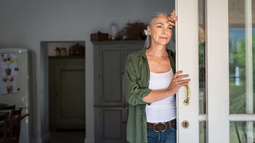 Mature woman thinking at home entrance