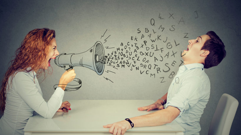 angry young woman with megaphone shouting at stressed scared man blown away by wave of alphabet letter