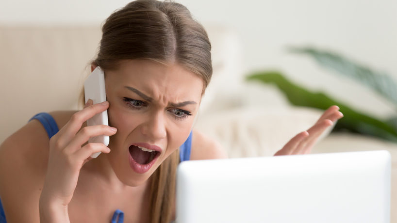 Angry dissatisfied young woman calling customer support, arguing on phone