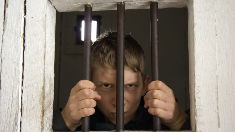 Angry man behind ancient prison bars