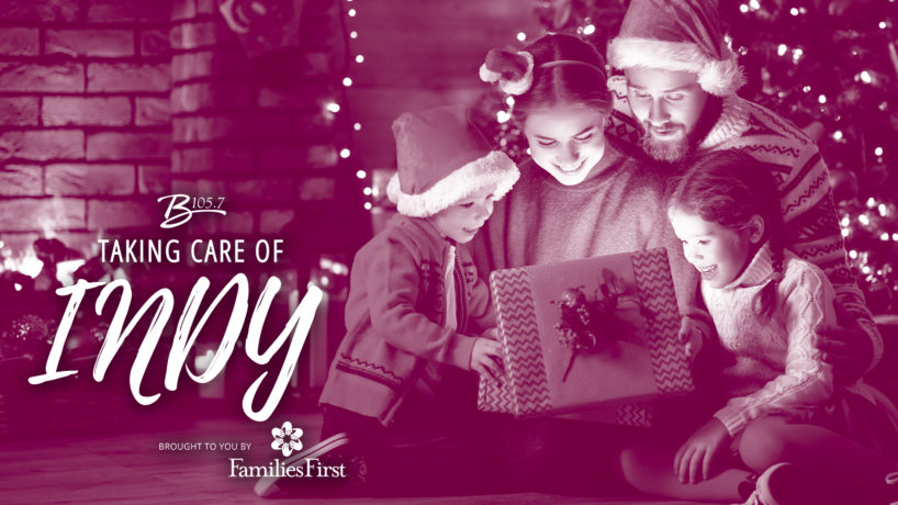 Taking Care of Christmas banner, family all looking around a present