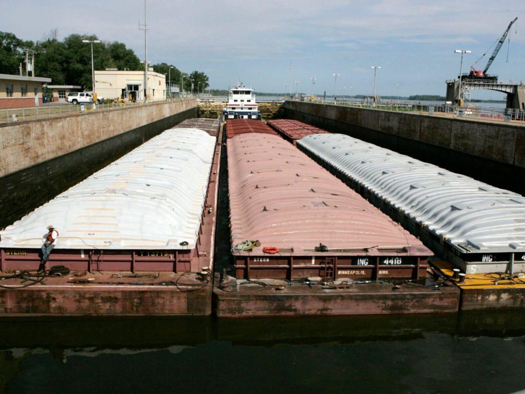 FILE - A towboat and its barges are shown in the channel at lock and dam 25 at Winfield, Mo., on Aug. 19, 2005. The U.S. Army Corps will spend $732 million to expand the congested lock and dam in Missouri. Federal officials said adding a second lock in Winfield will reduce travel time for barges and allow for two-way traffic. Funding for the lock's construction was part of a broader Biden administration announcement Wednesday, Jan. 19, 2022, to provide the Army Corps with $14 billon for infrastructure and environmental restoration projects. (AP Photo/James A. Finley, File)