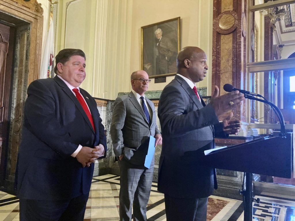 Illinois House Speaker Emanuel "Chris" Welch, D-Hillside, briefs reporters on a budget deal reached among Democrats, including $1.8 billion in tax relief in part by freezing an automatic motor fuel tax increase, Thursday, April 7, 2022, in Springfield, Ill. But despite the extra cash, officials are relying on taking money from an account set up to clean up leaking underground fuel-storage tanks to backfill the road-building fund's lost motor-fuel tax revenue. Behind Welch is Gov. J.B. Pritzker, left, and Senate President Don Harmon, D-Oak Park. (AP Photo/John O'Connor)