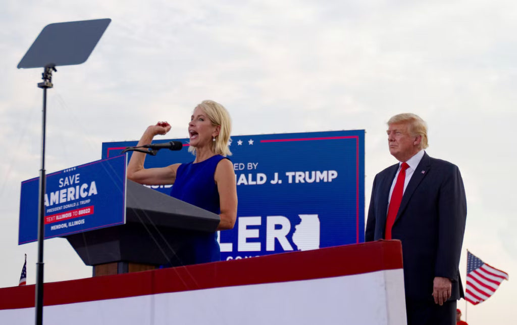 U.S. Rep. Mary Miller, of Illinois, speaks as former President Donald Trump stands behind her on stage at a rally at the Adams County Fairgrounds in Mendon, Ill., Saturday, June 25, 2022. (Mike Sorensen/Quincy Herald-Whig via AP)