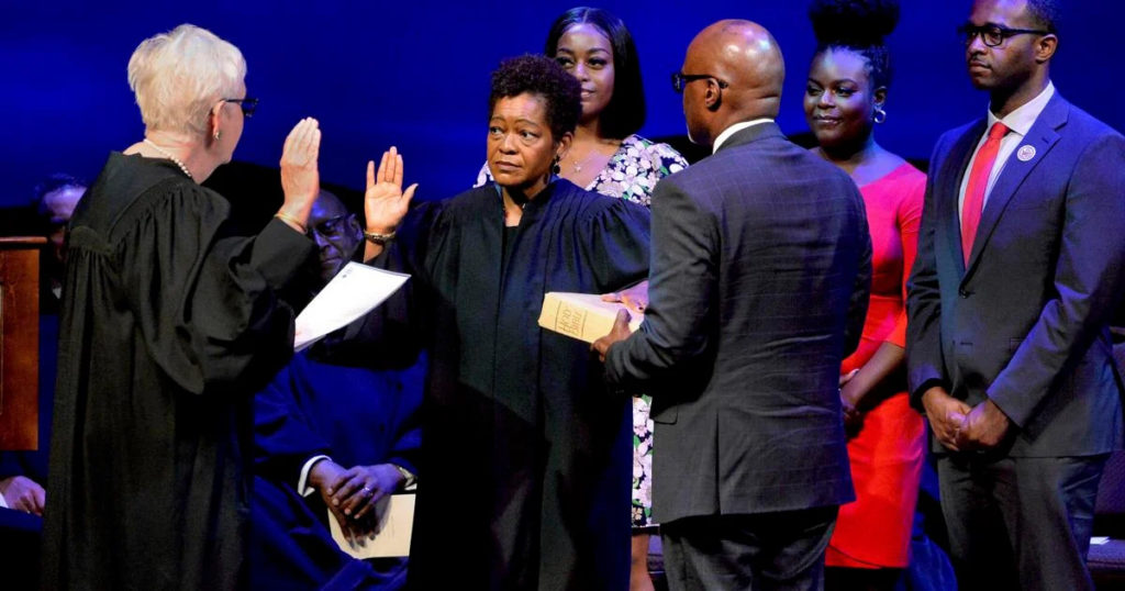 Lisa Holder White, center left, is sworn in as a Justice of the Supreme Court of Illinois by Justice, First District, Supreme Court of Illinois Mary Jane Theis during White's Installation Ceremony at the Abraham Lincoln Presidential Library and Museum Thursday July 7, 2022, in Springfield, Ill. (Thomas J. Turney/The State Journal-Register via AP)
