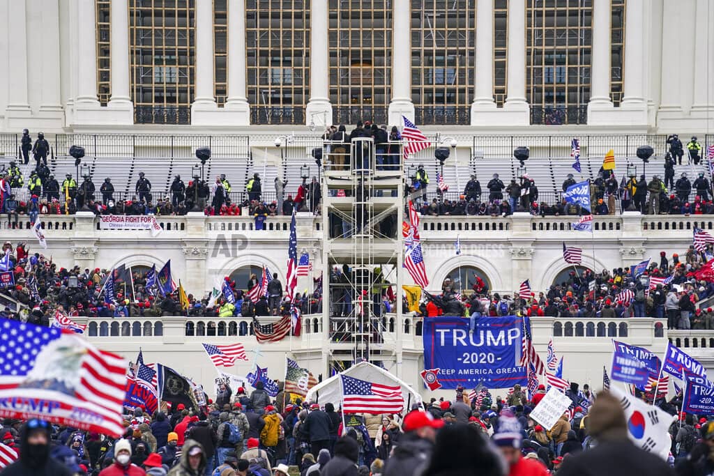 FILE - Insurrectionists loyal to President Donald Trump breach the Capitol in Washington, Jan. 6, 2021. Shane Jason Woods, 44, of Auburn, Illinois, pleaded guilty Friday, Sept. 9, 2022, to felony charges for assaulting, resisting, or impeding law enforcement officers and a related federal assault charge, prosecutors said.(AP Photo/John Minchillo, File)