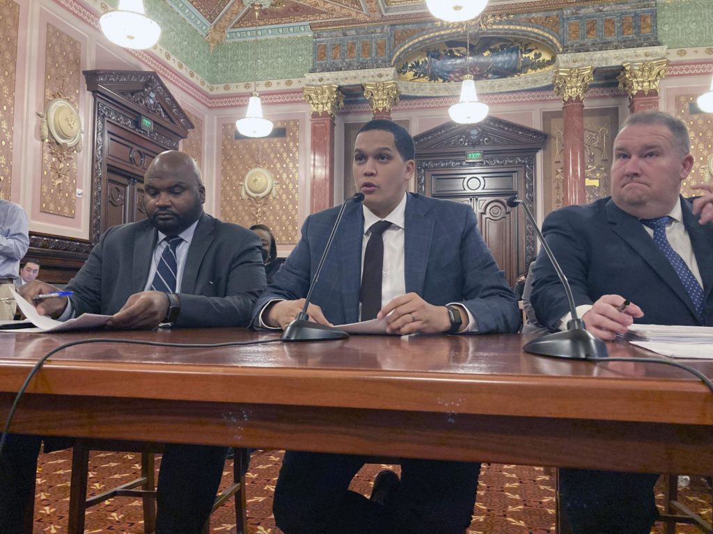 FILE - Illinois state Sen. Robert Peters, D-Chicago, center, testifies before the Senate Executive Committee, Dec. 1, 2022, on his legislation to clarify the SAFE-T Act, a sweeping criminal justice overhaul that notably eliminates cash bail. Accompanying Peters are co-sponsors, Sen. Elgie Sims, D-Chicago, left, and Sen. Scott Bennett, D-Champaign. Illinois lawmakers' effort to end cash bail is in the state Supreme Court's hands after justices heard arguments Tuesday, March 14, 2023, on behalf of top Democrats, and a group of prosecutors and sheriffs who are challenging the law. (AP Photo/John O'Connor, File)