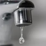 macrophotographofachromefaucetdrippingwater