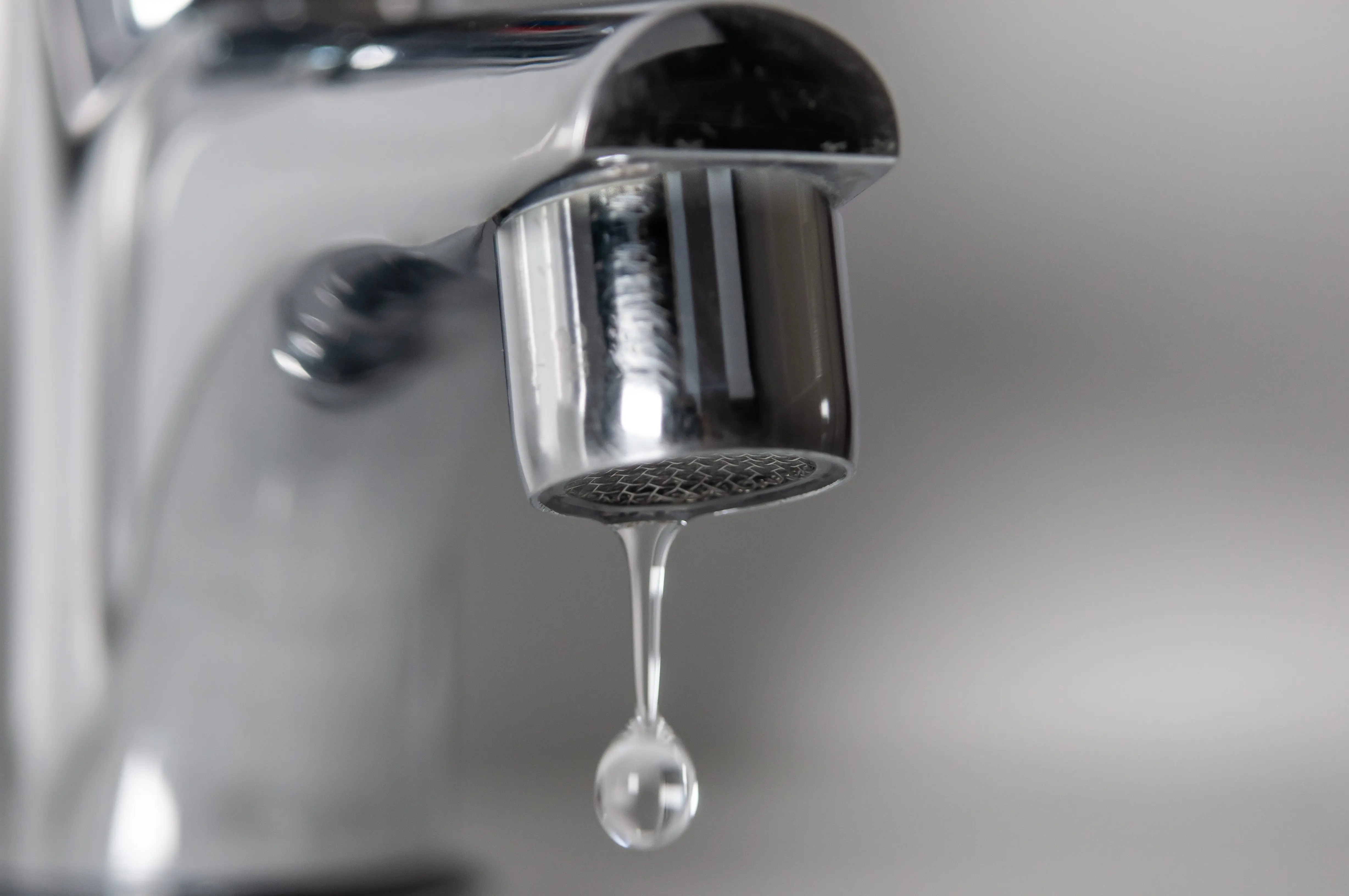 macrophotographofachromefaucetdrippingwater