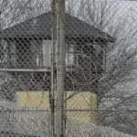 FILE - Security fences surround the Illinois Department of Corrections' Logan Correctional Center on Nov. 18, 2016, in Lincoln, Ill. A report Tuesday, Sept. 20, 2022, by a state inspector general found that an Illinois prison system administrator improperly ordered the hiring of a family member for a Department of Corrections position that was never authorized. (AP Photo/Seth Perlman, File)
