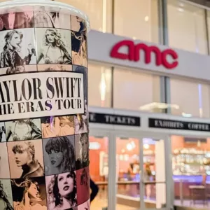 Taylor Swift The Eras Tour Film logo in front of AMC theaters