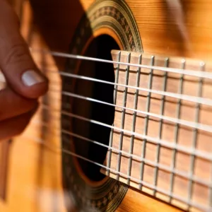 Closeup of hand of woman plays an acoustic guitar.