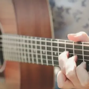 close of of hand playing guitar