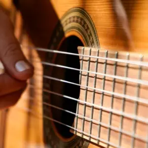 A woman plays an acoustic guitar.
