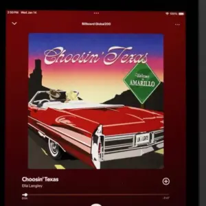 An Apple iPad displays the Spotify music streaming application^ which is playing the song "Choosin' Texas" by the artist Ella Langley