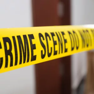 crime scene tape in front of room door with blurred background