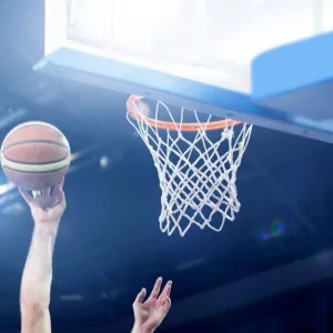 Ball in hoop at basketball game. Athletic competitions and games concept.